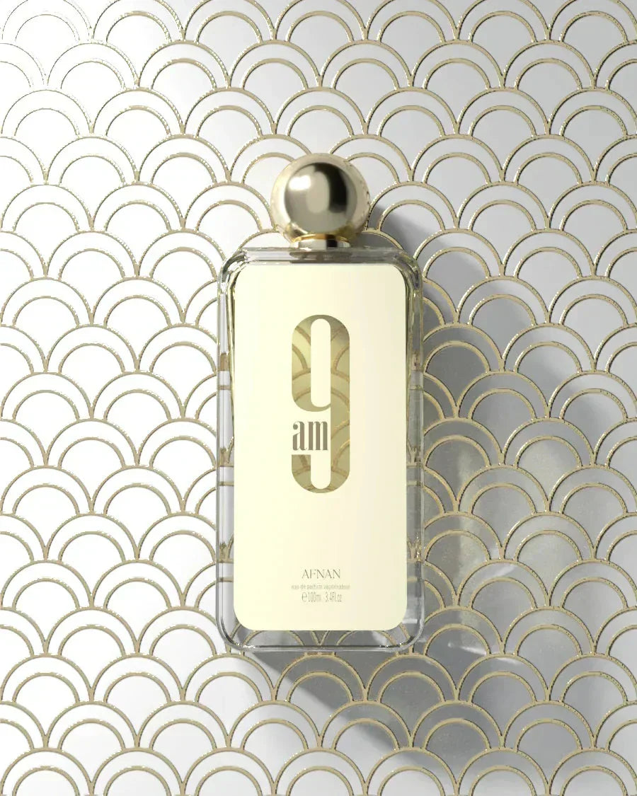The image displays a transparent perfume bottle with a golden cap, set against a geometric patterned background composed of overlapping arches in gold and white.  Below this is the brand name "AFNAN" in smaller, capitalized letters. The product specifications "eau de parfum vaporisateur," "100ml," and "3.4fl.oz" are listed at the bottom of the label. The overall aesthetic is luxurious and modern.