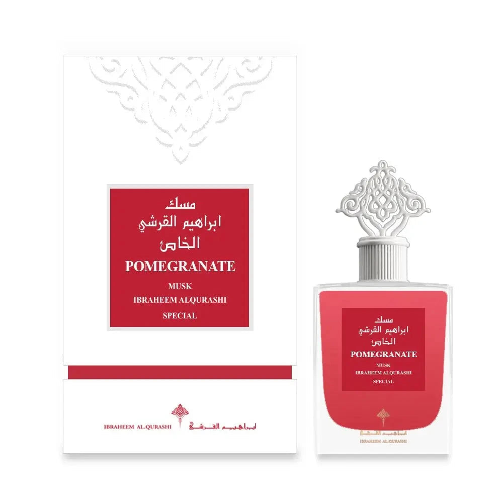 The image shows a set of a perfume product, including the packaging and the bottle. The product is "POMEGRANATE MUSK" by Ibraheem Al Qurashi. The packaging is predominantly white with a red label in the center that matches the red label on the clear glass perfume bottle. The bottle has a clear, ornate design with a silver-colored, intricately designed cap. The packaging and bottle feature Arabic calligraphy and English text, indicating the fragrance's name and the brand, described as special.