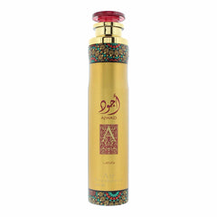 A tall, cylindrical gold can of Ajwad air freshener by Lattafa, featuring Arabic calligraphy in red, a decorative filigree “A” on the front, ornate teal and red patterns around the upper and lower edges, and a translucent red cap on top.