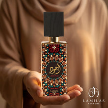 The Lattafa Ajwad perfume bottle, featuring a colorful geometric mosaic pattern, is held elegantly in cupped hands.
