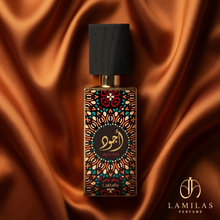 Lattafa Ajwad perfume bottle featuring a detailed colorful geometric label and black cap, set against luxurious bronze silk draping.