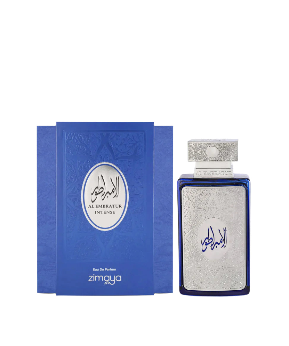 A bottle and packaging of Al Embratur Intense Eau De Parfum by Zimaya. The perfume bottle is deep blue with an ornate silver front panel and matching silver cap, both featuring intricate embossed patterns. The name "Al Embratur Intense" is displayed in elegant Arabic and English script. The box echoes the bottle’s design with a similar blue and silver color scheme and embossed detailing, emphasizing a luxurious and regal aesthetic.
