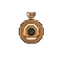 The image is of a perfume bottle displayed against a white background. The bottle has an octagonal shape with a faceted design, giving it the appearance of a cut gem. It is colored in rich gold tones with intricate patterns and textures on its surface that suggest a sense of luxury and opulence.  The cap of the bottle matches the golden design and has a geometric shape consistent with the overall aesthetic.