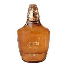  The image displays a perfume bottle of "Al Kaser" by Zimaya. The bottle has a broad, rounded base and tapers slightly toward the top. It is made of a translucent brown glass that gives it a warm, amber appearance. The cap is a detailed golden sculpture of a falcon's head, symbolizing luxury and possibly the fragrance's inspiration. The name "Al Kaser" is elegantly inscribed on the bottle in white cursive script.