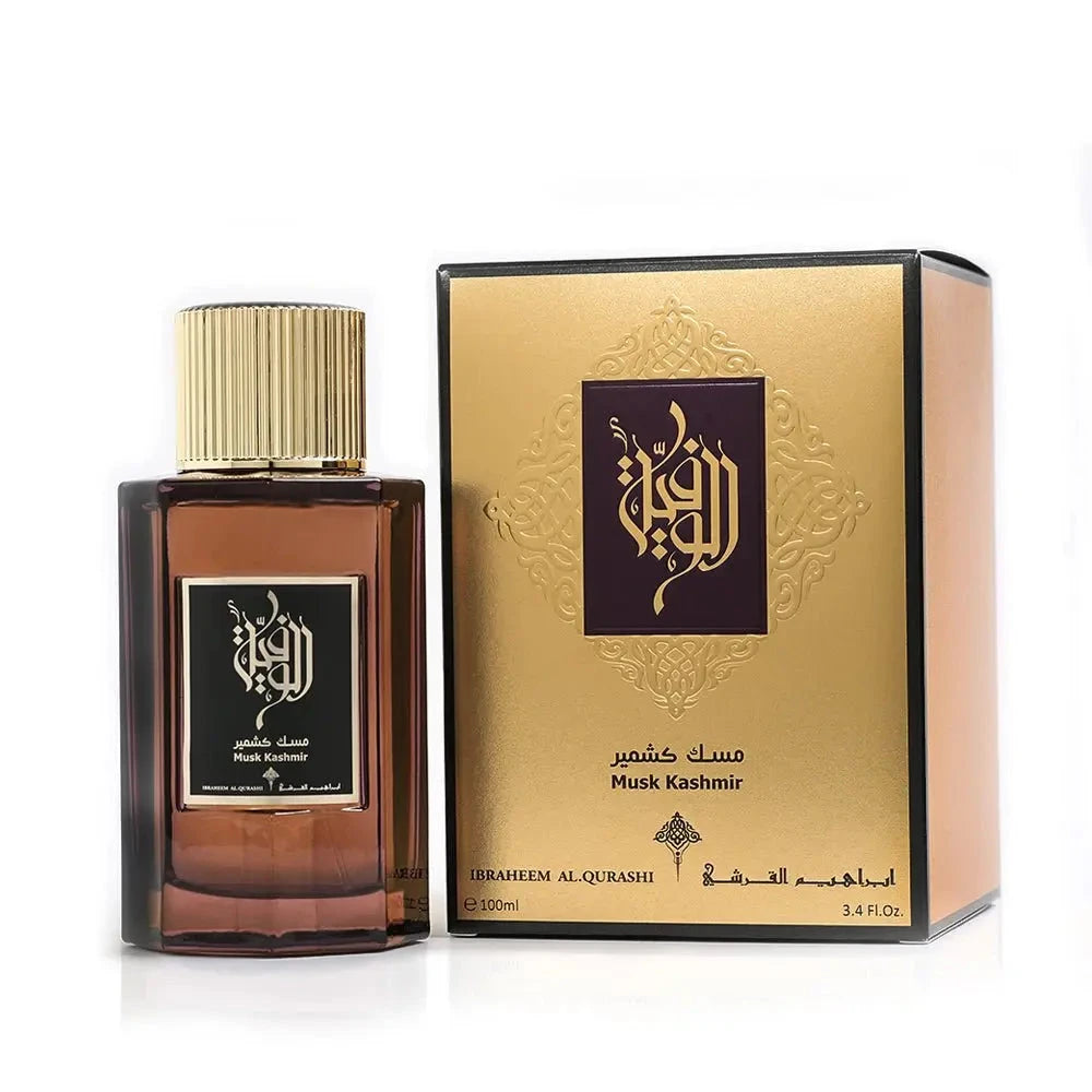 The image displays a dark amber glass perfume bottle with a gold cap next to its packaging. The label on the bottle and the packaging features Arabic calligraphy and English text, reading "Musk Kashmir" by Ibraheem Al Qurashi. The packaging box is gold with black and gold decorative elements and text, which gives an impression of luxury. 