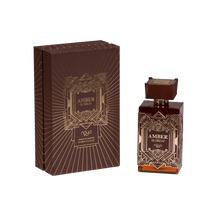 A perfume product set titled "AMBER IS GREAT," featuring a square glass bottle with brown tones and intricate geometric patterns. The cap matches the bottle's design. Accompanying the bottle is a similarly patterned brown box with gold line art and lettering, stating "AMBER IS GREAT" at the center, and the brand "náyá" at the bottom. The background is white.