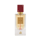 Image of a rectangular clear glass perfume bottle with a red cap embellished with two crystals. The bottle features a gold label with intricate arabesque designs and Arabic calligraphy that reads '??? ????' (Ana Abiyedh), with 'ROUGE' printed in red below. Below the gold label is the brand logo in gold with a flame-like design and the word 'Lattafa'. The perfume liquid appears to be a pale amber color, and the overall design suggests luxury and exotic allure.