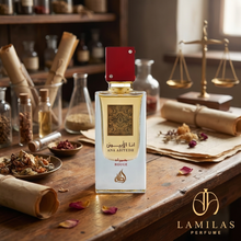 The Ana Abiyedh Rouge perfume bottle featuring a red cap, displayed on an antique wooden table with apothecary tools.