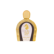 The image shows a product, likely a bottle of perfume, presented against a white background for a clean and professional look. The bottle has a distinctive horseshoe shape with a gold color scheme. It features a white label with golden edges, showcasing an embossed golden horse's head and Arabic calligraphy.  The cap of the bottle is textured, suggesting a design that complements the luxurious appearance.