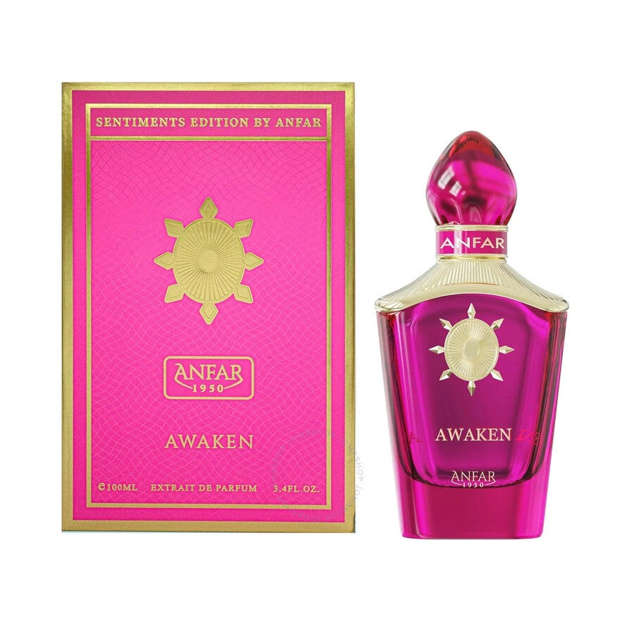 A pink, glass perfume bottle with a sculpted gold neck and a matching magenta-and-gold cap stands next to its coordinating pink box. The box features gold accents and the “ANFAR 1950” logo, as well as a sunburst-style emblem in the center and the word “AWAKEN” at the bottom.