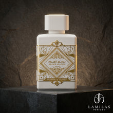 Lattafa Bade'e Al Oud Honor and Glory white perfume bottle featuring an intricate gold geometric design, displayed on black stone.