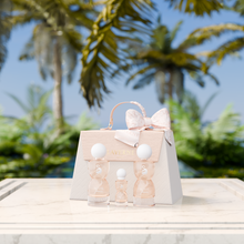 Laverne Sense Forever perfume trio displayed before a beige gift bag, set outdoors with palm trees in soft focus.