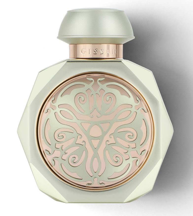 Gissah Cueva Verde perfume bottle in soft green with rose gold ornamental detailing and a faceted round shape.