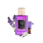 The image features a bottle of "Dark Lavender" perfume by Ibraheem Al Qurashi. The bottle is made of glass with a vibrant purple color and is capped with a gold-colored top. The front label has Arabic calligraphy and the name of the scent in English. Adjacent to the bottle are sprigs of purple lavender, a few vanilla pods, and white flowers, which are likely to be part of the fragrance's notes.