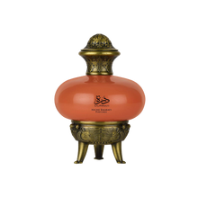 Durrah by Niche Emarati Perfumes Lattafa in a coral-colored round bottle with ornate antique gold cap and decorative tripod base.