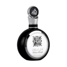 A sleek black perfume bottle with a silver cap and intricate detailing. The cap is adorned with stylized Arabic calligraphy that reads "Lattafa." The central part of the bottle features a silver emblem of an ornate flower, encircled by a rope-like border with the text "Fakhar Lattafa" beneath it. The design elements give the product a luxurious and masculine appeal.