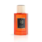 This is an image of a rectangular, transparent orange perfume bottle with a white cap. The front of the bottle has a black label with golden Arabic calligraphy and the English words "Golden Amber" beneath it. The bottle is presented against a plain white background, highlighting the vibrant orange color of the perfume liquid inside.