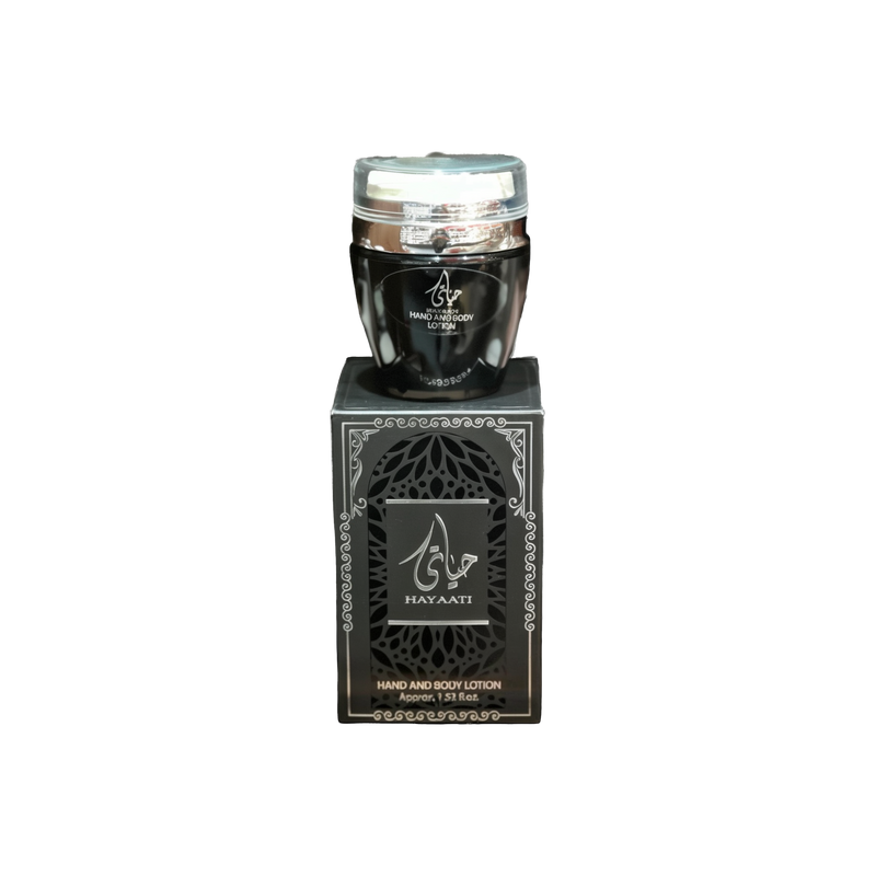 The image shows a product named "Hayaati Black Hand and Body Lotion." The lotion comes in a sleek, black container with a clear lid. The container is placed on top of a matching black box with elegant silver patterns and Arabic calligraphy. The box also features the product name "Hayaati" prominently. The packaging has a sophisticated and luxurious appearance, indicating a high-quality skincare product. The container holds approximately 1.53 fluid ounces of lotion.