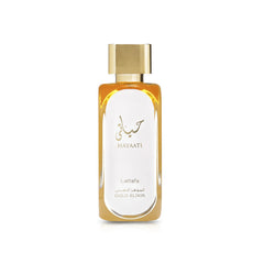 A rectangular glass perfume bottle filled with golden liquid, featuring a sleek gold cap. The front is printed with Arabic and English text reading “Hayaati Lattafa Gold Elixir.”