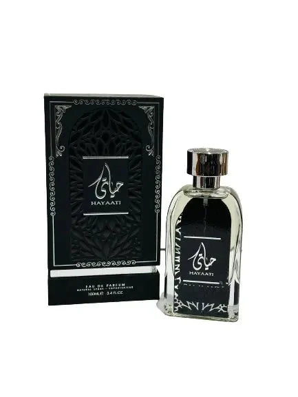 A bottle of Hayaati perfume by Lattafa next to its packaging box. The perfume bottle is clear with a black label featuring the Hayaati logo in white Arabic calligraphy. The box is black with a textured design, silver accents, and the same logo as the bottle.