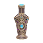 Ibhaar concentrated perfume oil bottle with ornate bronze filigree design and blue gemstone accents.