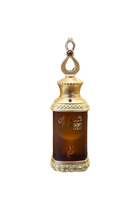 This image features a perfume bottle labeled "Kayaan Gold" resting on a glass surface. The bottle has a regal design with a gold-toned cap adorned with decorative elements and a loop on top, suggesting it can be used as a pendant or for easy carrying. The dark amber liquid inside indicates the perfume might have a rich and possibly woody or oriental fragrance.