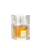 This image displays a square-shaped perfume bottle with a clear crystal-like design. The bottle has a substantial, geometrically cut glass structure that reflects light, enhancing the rich golden-yellow color of the perfume inside. The cap is a clear cube