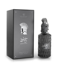 Le Falcone Niche Collection’s “Khulood” perfume against a white background: on the left, a closed matte‑dark rectangular gift box with a glossy silver‑tone front panel featuring the Le Falcone logo, a stylized warrior‑helmet graphic, Arabic calligraphy and the word “Khulood,” plus “Extrait de Parfum 85 ml / 2.8 fl oz” printed below. On the right, the box is opened to reveal the perfume bottle resting on a raised beige interior platform.