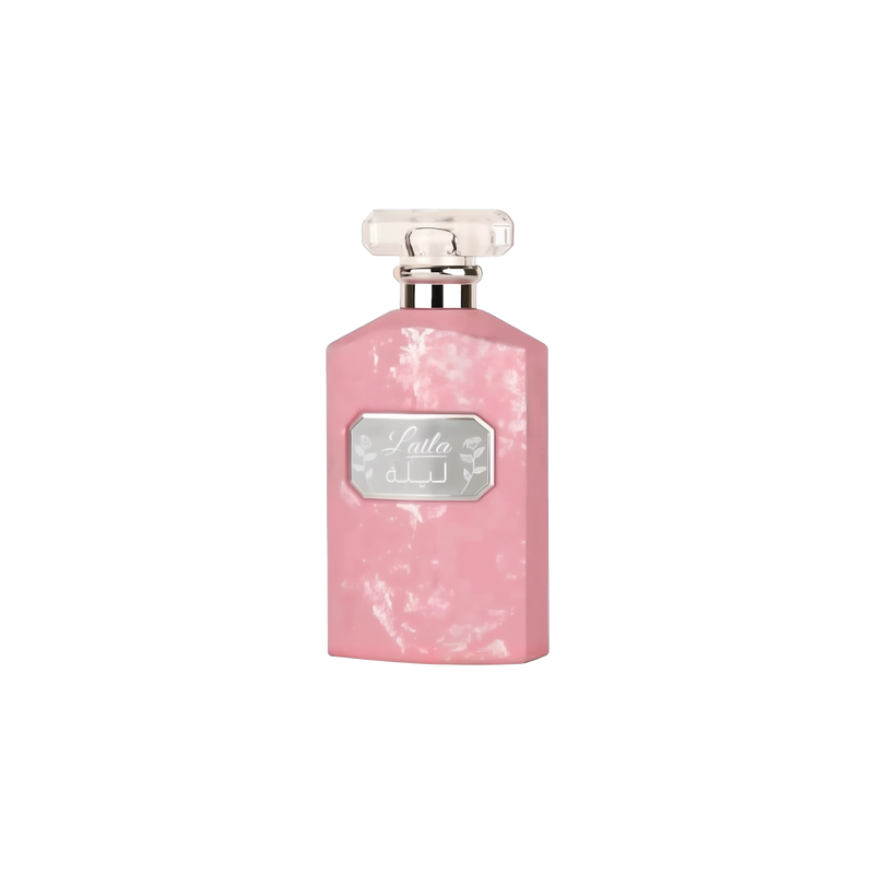 The image shows a flat, rectangular-shaped perfume bottle with a textured pink surface that has a marbled or distressed look. The bottle has a clear, rectangular glass cap. On the front, there's a label with the name "Laila" in stylized script, along with Arabic script beneath it. The label is framed by a silver border, giving the bottle a feminine and elegant appearance.