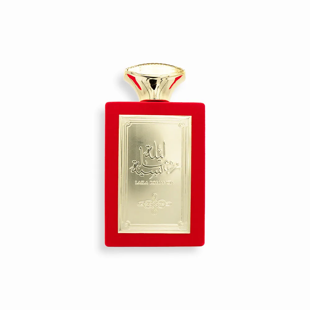 A luxurious bottle of Laila Romancia Eau De Parfum by Sahari, featuring a striking red velvet-textured rectangular design with an elegant gold metallic plate engraved with Arabic calligraphy and the product name. The cap is gold-toned with a flared shape, enhancing the perfume’s sophisticated and regal aesthetic.