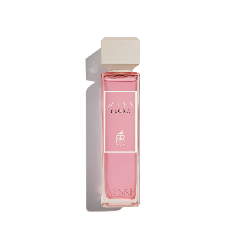 Assaf Miss Flora perfume bottle with a tall frosted blush-pink glass body, white rectangular cap, and minimalist label.