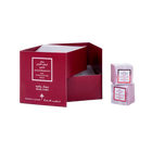 Open maroon Ebraheem Al Qurashi Pomegranate Musk Cubes gift set packaging next to two pink wrapped solid perfume cubes.ebraheem-al-qurashi-pomegranate-musk-cubes-packaging.jpg