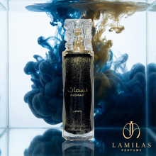 Lattafa Nasmaat shimmering black perfume bottle with a crystal cap, set against swirling blue and gold ink in water.