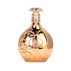 Gold reflective Nyla perfume bottle with ornate swirling design.