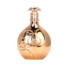 Gold reflective Nyla perfume bottle with ornate swirling design.