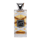 The image displays a perfume bottle with the following attributes:  The bottle is rectangular with a clear glass design, allowing a view of the amber-colored perfume inside. A silver ribbon with the words "Oud Mood" printed in a repeating pattern wraps around the bottle. The central label is ornate with a black background and white decorative border; it features Arabic calligraphy and the word "Reminiscence" in English script.