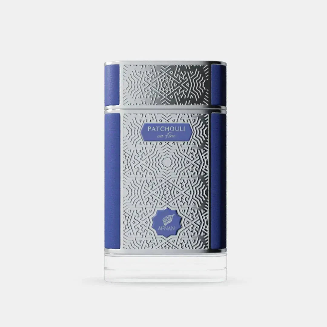The image presents a perfume bottle with an elegant design. The bottle is clear glass with an intricate white geometric pattern covering most of its surface. It has a solid navy blue cap and a matching navy blue band that runs horizontally around the center of the bottle, providing a bold contrast to the white pattern. 