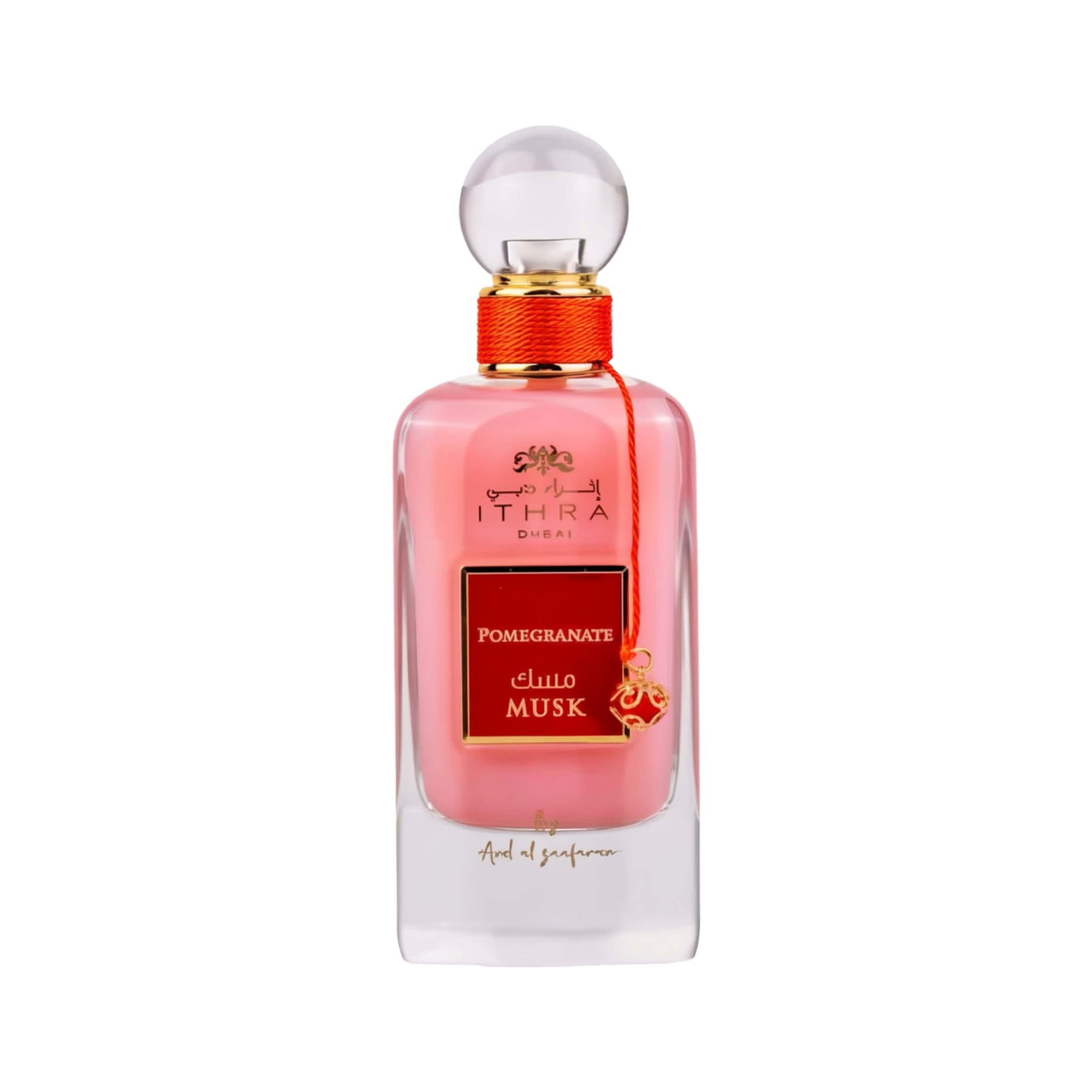 A bottle of Ithra Dubai Pomegranate Musk perfume by Ard Al Zaafaran. It features a clear glass design with a white gradient base and a round glass cap. The perfume liquid has a soft pink hue, and there's a gold-colored brand emblem at the top, with the name of the scent on a red and gold label in the center. A small gold charm with intricate detailing is attached to the neck of the bottle with a red string. The presentation suggests a feminine and luxurious fragrance.