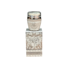 The image shows a product named "Pure Musk Hand and Body Lotion." The lotion is packaged in a light beige container with a clear lid and placed on top of a matching beige box adorned with intricate, elegant silver patterns and Arabic calligraphy. The box prominently features the product name "Pure Musk." The sophisticated packaging suggests a luxurious and high-quality skincare product.