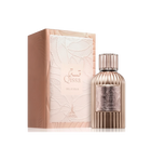 A round metallic perfume bottle with vertical ridges, labeled “Qissa Delicious,” featuring a matching ridged cap, standing beside a pale pink box with an embossed leaf design.