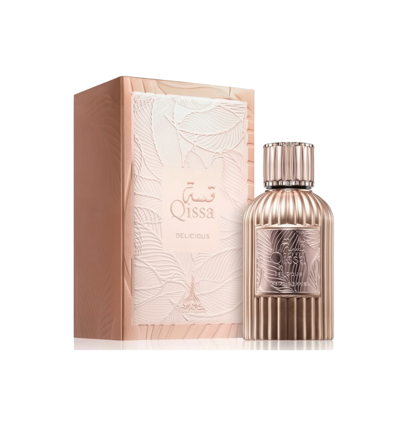 A round metallic perfume bottle with vertical ridges, labeled “Qissa Delicious,” featuring a matching ridged cap, standing beside a pale pink box with an embossed leaf design.