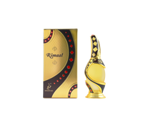 A luxurious perfume bottle and its matching box from Khadlaj Perfumes. The box is gold with black and red accents, featuring the brand name "Rimaal" in elegant script. The bottle is gold with intricate black and red detailing, designed with an ornate, curved shape that exudes elegance and sophistication.