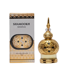 The image shows a product called "Shamookh" by Khadlaj, which is a concentrated perfume oil. The product is presented in an ornate 20ml bottle with a spherical design. The bottle is gold with intricate patterns and a decorative, pointed cap, giving it a luxurious and elegant appearance. The packaging box complements the bottle's design with a gold and black theme, featuring the product name "Shamookh" in bold letters.