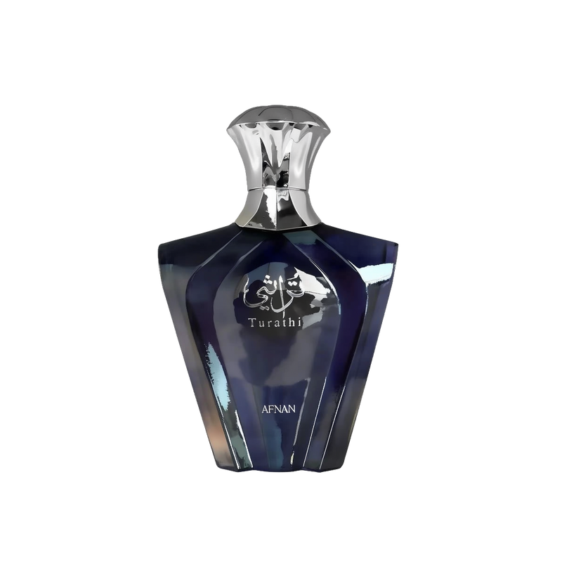 The image presents a sleek perfume bottle with a geometric design. The bottle has a deep blue color with a glossy, reflective surface, and features silver accents. The cap is silver and has an inverted cup shape that complements the bottle's shoulders. On the front, in silver lettering, is the name "Turathi" beneath an emblem with Arabic calligraphy, indicating the fragrance name or brand.