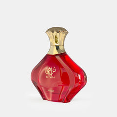 The image features a red perfume bottle with a gold-toned cap. The bottle is shaped like a multifaceted gem, with a smooth and shiny surface that catches and reflects the light. Arabic script is prominently displayed in white on the bottle, with the transliteration "Turathi" just below it, indicating the name or collection of the fragrance. The word "AFNAN" is also visible at the bottom of the bottle, designating the brand. The overall appearance of the bottle is luxurious and suggests an exotic origin.