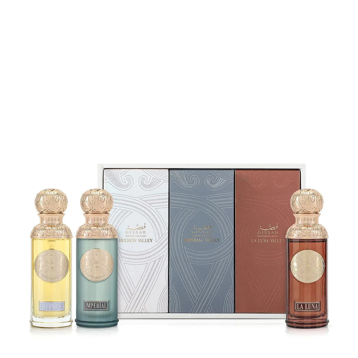 A set of three Gissah perfume bottles with their matching boxes. The bottles are labeled "Hudson" (clear yellow), "Imperial" (blue-green), and "La Luna" (dark amber), each featuring an ornate gold cap and intricate gold emblem. The boxes are designed in corresponding colors: white for Hudson, blue for Imperial, and brown for La Luna, each adorned with elegant patterns and the Gissah brand name in both English and Arabic.