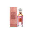 A cylindrical pink velvet container labeled ‘Velvet Rose’ by Lattafa, shown beside a clear glass perfume bottle containing pink liquid, featuring a rose-gold neck, a crystal-like cap, and a matching gold label on the front.