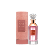 A cylindrical pink velvet container labeled ‘Velvet Rose’ by Lattafa, shown beside a clear glass perfume bottle containing pink liquid, featuring a rose-gold neck, a crystal-like cap, and a matching gold label on the front.