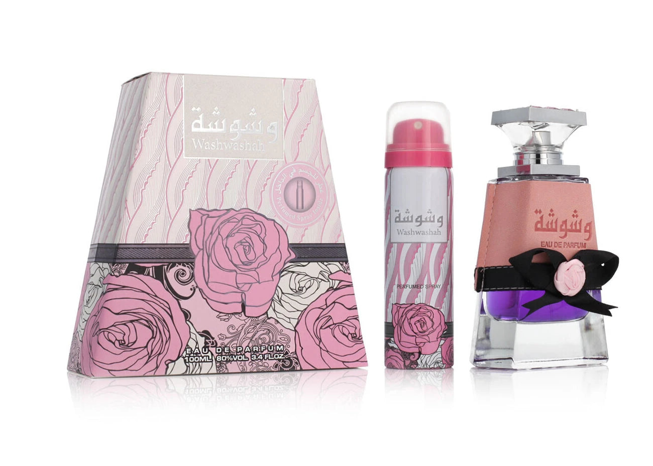 A triangular pink box with swirling rose designs, labeled “Washwashah” by Lattafa, shown alongside a matching pink aerosol spray can and a clear glass perfume bottle with purple liquid, a pink wraparound band, and a black bow accent.