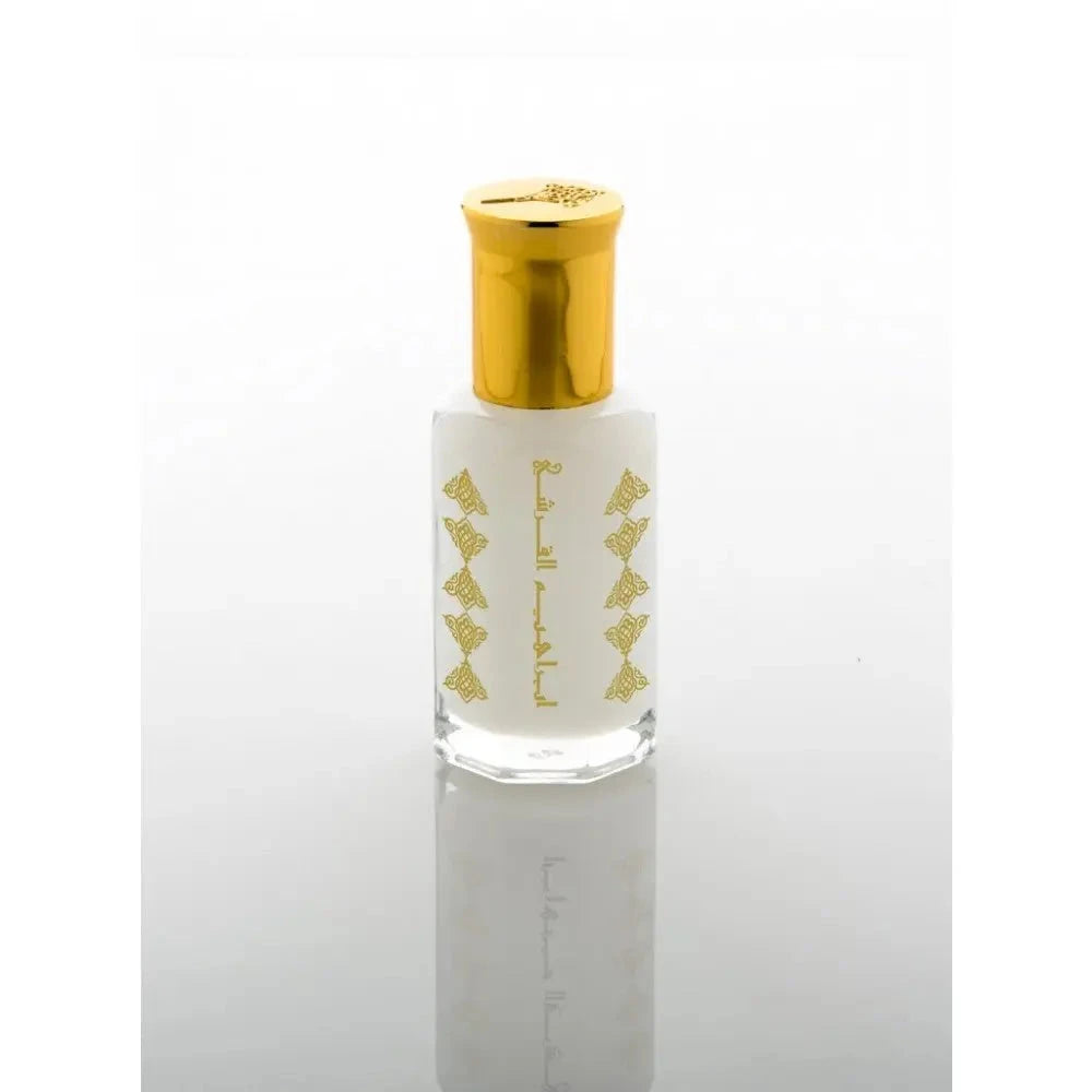 An elegant clear glass perfume bottle with a frosted finish and a shiny golden cap. The bottle is adorned with golden Arabic calligraphy and decorative elements that add to its sophisticated look. The reflection of the bottle is visible on the surface below, suggesting a clean and refined aesthetic.